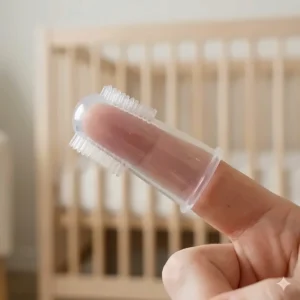 A diagram showing how to fit the silicone finger toothbrush for babies onto an adult finger for safe oral hygiene.